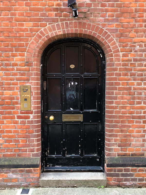 Beautiful arched nine-panel black door, Westminster, London, May 2022